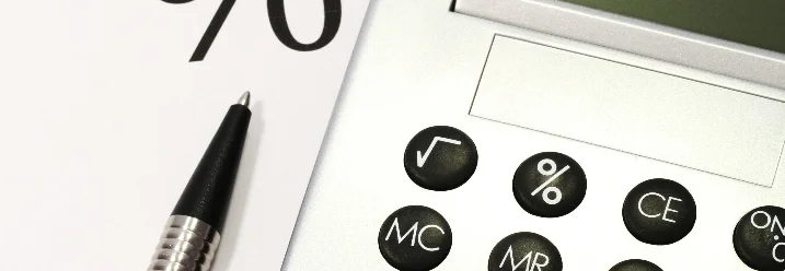 Taschenrechner und Stift auf Papier mit Prozentzeichen